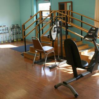 A physical therapy room with exercise equipment and stairs for rehabilitation exercises.