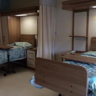 A hospital room with two beds separated by a curtain.