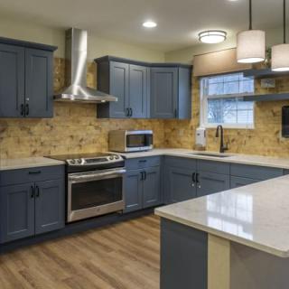 A modern kitchen with blue cabinets and stainless steel appliances.