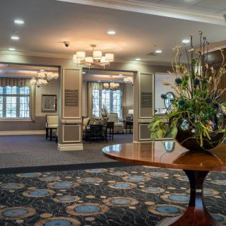 An elegantly decorated lobby with chandeliers and floral arrangements.
