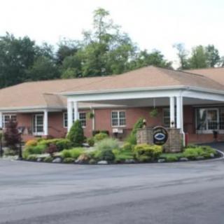 A brick building with a covered entrance surrounded by well-maintained landscaping.