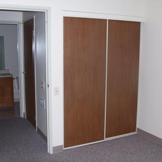 A room with a wooden sliding door closet.