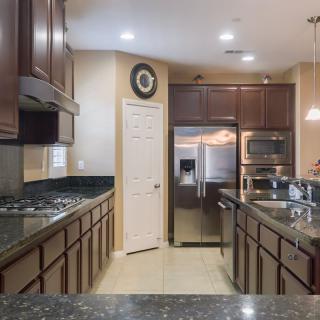 A modern kitchen with dark wood cabinets and stainless steel appliances.