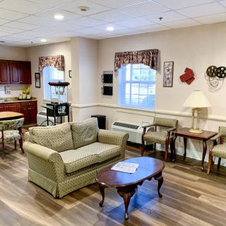 A cozy living room with a sofa, chairs, and a coffee table on hardwood flooring.