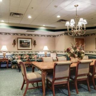 A well-decorated dining room with a long wooden table, elegant chairs, and a chandelier.