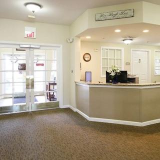 A bright and welcoming office lobby with a reception desk and entrance doors.