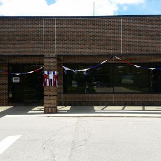 A storefront decorated with banners, showcasing a brick facade under a clear sky.