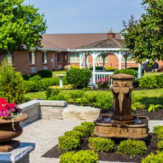 A serene garden area featuring a beautiful fountain and lush greenery.