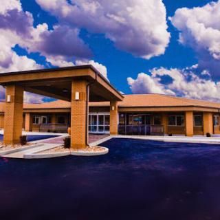 A modern building under a vibrant, cloud-filled sky.