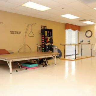 A well-equipped physical therapy room featuring a treatment table and various exercise tools.