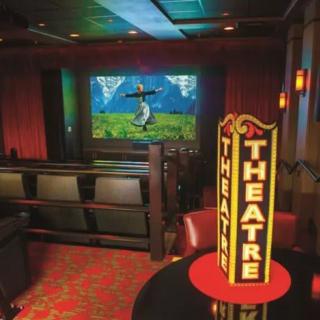 A cozy home theater setup with a large screen and comfortable seating.