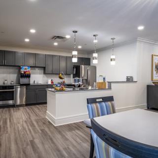 A modern kitchen with an open dining area featuring sleek appliances and stylish lighting.