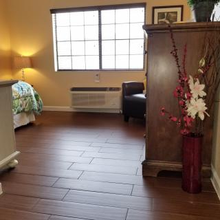 A cozy bedroom with wooden flooring and elegant decor.