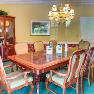 A well-furnished dining room with elegant chairs and a chandelier.