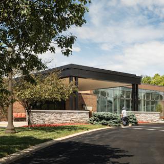 A modern commercial building with a welcoming entrance surrounded by landscaped greenery.