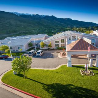 Aerial view of a hospital building set against picturesque mountains.