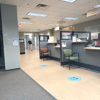 A spacious office reception area with waiting chairs and service counters.
