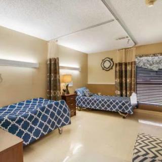 A well-lit hospital patient room featuring two beds, designed for comfort and functionality.
