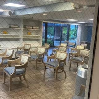 An empty waiting room with multiple chairs and a large window.