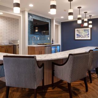 A modern conference or dining area with a stylish table, upholstered chairs, and contemporary lighting fixtures.