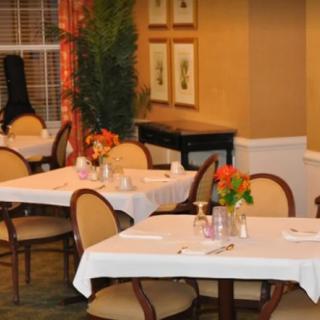 A cozy restaurant dining area with elegantly set tables and floral decorations.