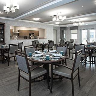 Elegant dining room with neatly set tables and modern lighting fixtures.