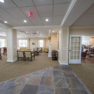 A spacious and well-lit common area in a residential facility, featuring comfortable seating arrangements and a welcoming atmosphere.