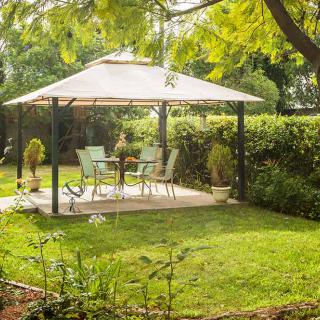 A tranquil garden setting with a gazebo and outdoor furniture on a sunny day.