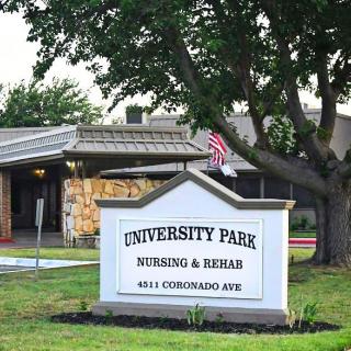 Sign for University Park Nursing & Rehab in front of the facility, surrounded by trees and an American flag.