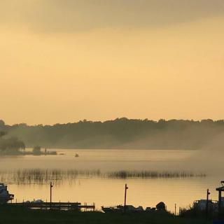 A serene view of a misty lake at sunset.