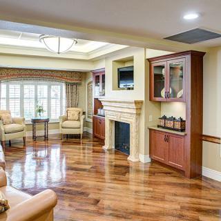 A spacious living room with hardwood floors, a fireplace, and comfortable seating.