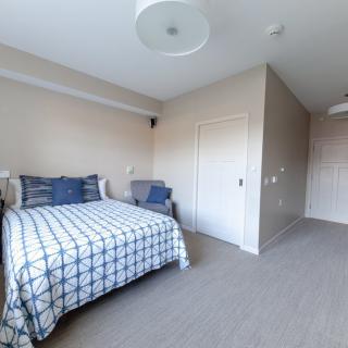 A minimalist bedroom with a neatly made bed and simple decor.