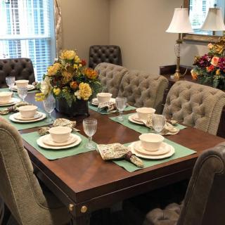A beautifully arranged dining table with elegant dinnerware and floral centerpieces in a cozy dining room.