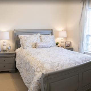 A cozy bedroom with a neatly made bed and matching nightstands, creating a serene and inviting atmosphere.
