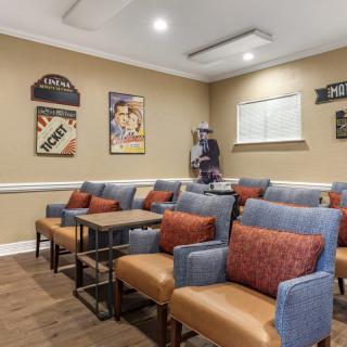 A cozy theater room with comfortable seating and classic movie posters on the wall.