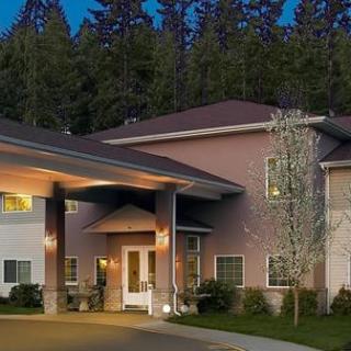 A residential building entrance with surrounding trees at dusk.