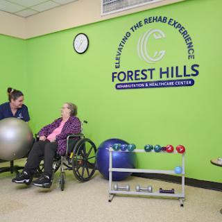 A caregiver assisting an elderly woman in a rehabilitation setting at Forest Hills, promoting health and wellness.