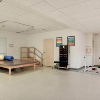 A physical therapy room equipped with exercise equipment and a treatment table.