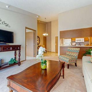 A cozy, well-decorated living room with a sofa, coffee table, and television.