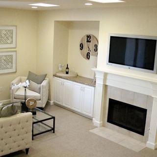 A cozy living room with a fireplace, wall-mounted TV, and elegant decor in neutral tones.