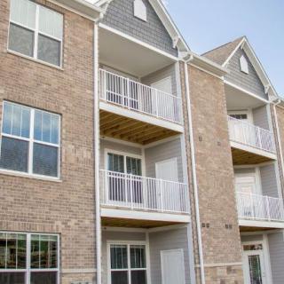 A modern apartment building with a brick exterior and multiple balconies.