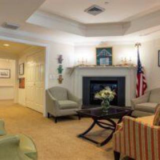 Cozy living room with a fireplace, comfortable seating, and an American flag.