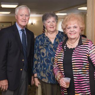 A cheerful group of three individuals posing together at a social gathering.