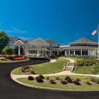 A well-maintained suburban building with a flag and landscaped lawn.