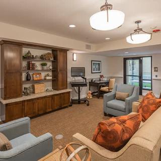 A cozy living room with comfortable seating, shelves, and warm lighting.