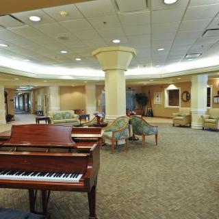 A spacious lobby featuring a grand piano and comfortable seating areas.