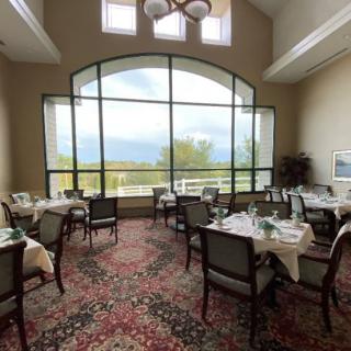 A well-lit restaurant dining area with large windows showcasing a scenic view.
