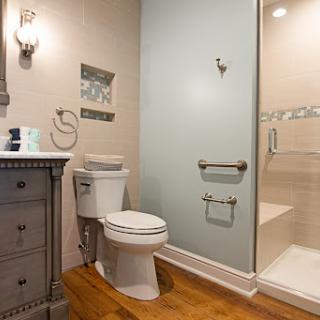 A stylish and modern bathroom featuring a clean design with a shower, toilet, and a wooden vanity.