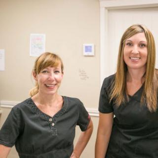 Two healthcare professionals smiling in their workplace.