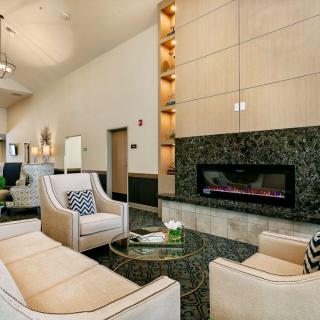 A modern living room with a cozy seating area and a stylish fireplace.